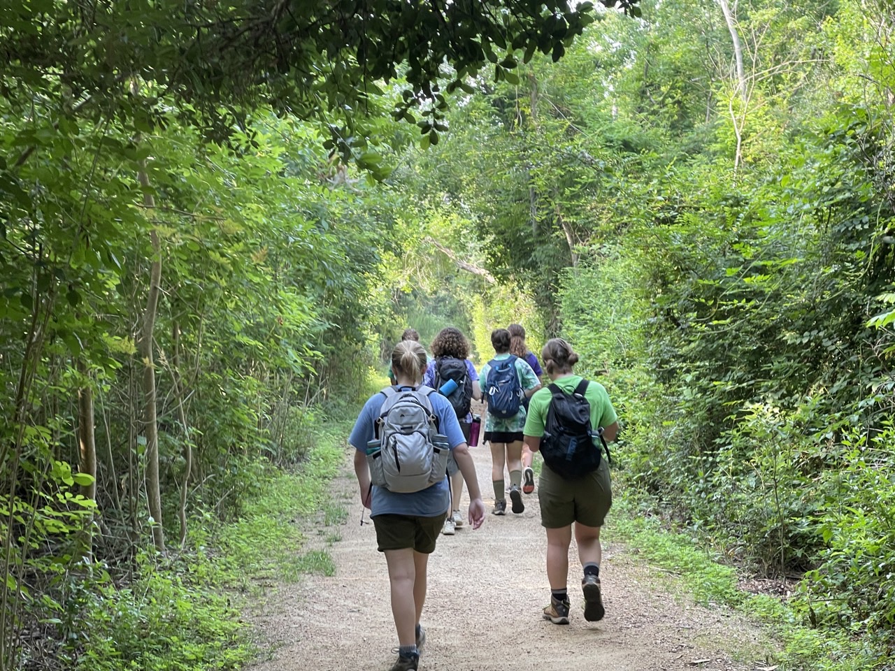 Troop 1965 Scouts hiking on a wooded trail